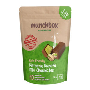 A tan and green pouch of Munchbox Keto Friendly Pistachio Kunafa Mini Chocolates showing individual chocolate bars and pistachios