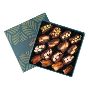 An open teal Bayara gift box filled with assorted stuffed dates containing pistachios, cashews, and almonds.